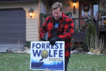 A candidate puts up a yard sign with the name Forrest Wolfe