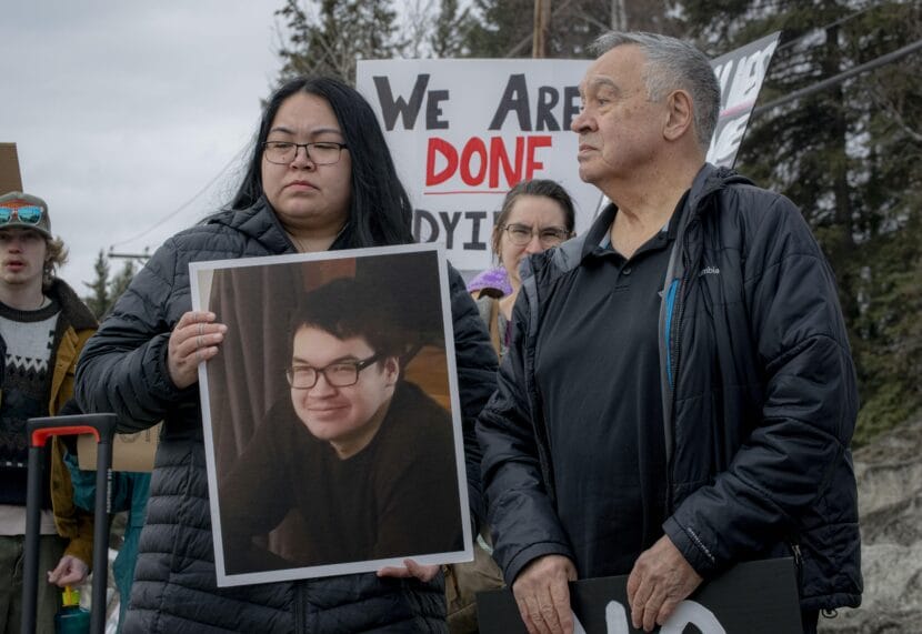 Linda Rexford holds a photo of her brother, William Rexford, while standing beside their father, Herman Rexford, at a protest in Fairbanks on April 11, 2026. William Rexford was shot and killed by Alaska State Troopers while experiencing a mental health crisis on Jan. 1, 2026.