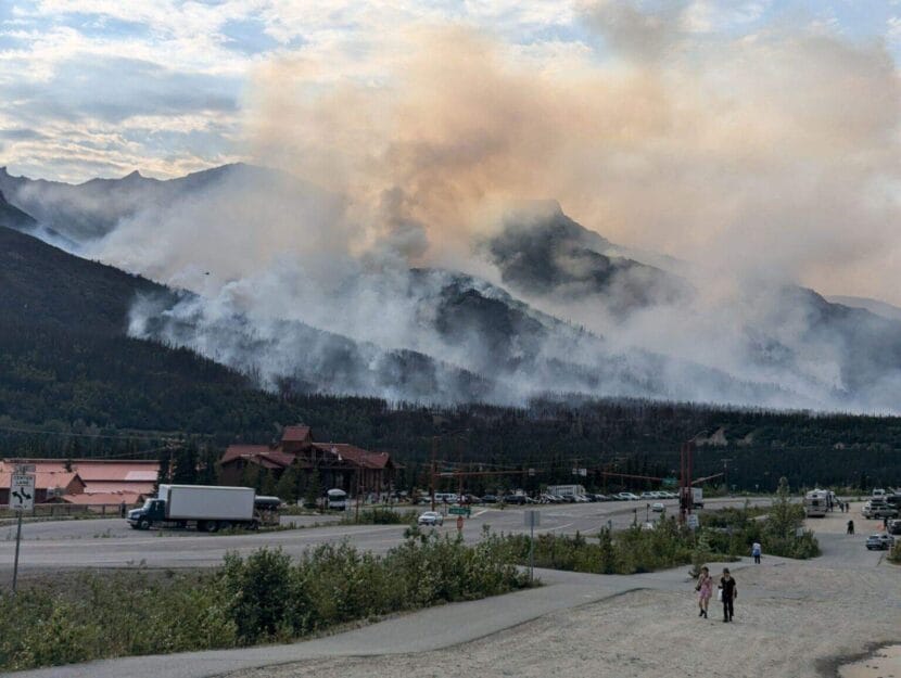 Smoke from a wildfire at the entrance area of Denali National Park hovers on June 30, 2024, on the hillsides behind hotels and businesses serving tourists.