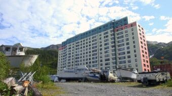 A colorful building stands in the distance with a parking lot of boats in the foreground.