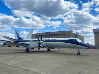 a 30-seat airplane that is blue and white under a blue sky with white clouds