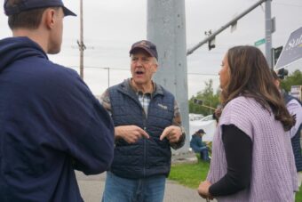Sen. Dan Sullivan, R-Alaska, talks to staffers on the morning of Aug. 18, 2026, at the intersection of the Seward Highway and Northern Lights Boulevard. The Midtown Anchorage intersection is a favored spot for candidate sign-waving, and Sullivan, who is running for re-election, was there with U.S. Rep. Nick Begich, R-Alaska, also running for re-election.