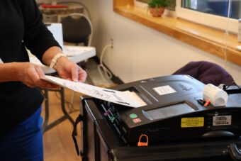 A poll worker helps a Petersburg voter submit their ballot during the Aug. 18 primary.