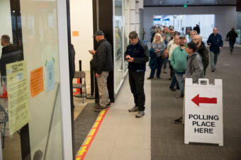 A line of people wait to vote.